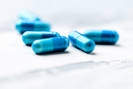 Blue pills on a white wooden table. Shallow depth of fieldの写真素材