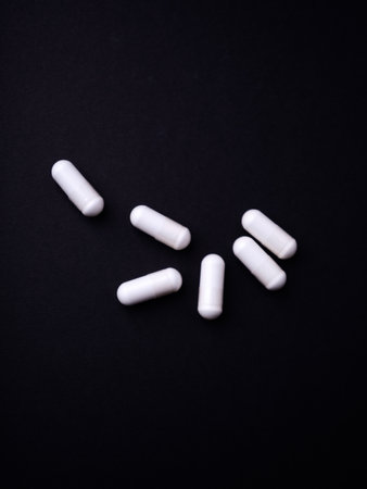 White pills on a black background. Top view. Copyspace.の写真素材