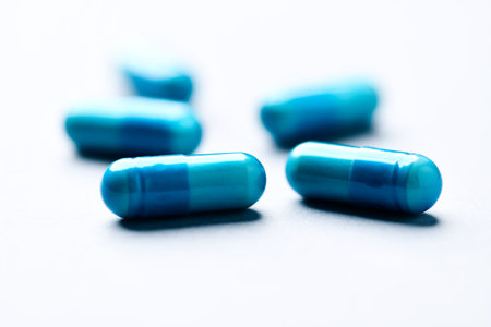 Blue pills on a white background. Focus on foreground, soft bokeh.の写真素材