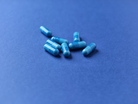 Blue pills on blue background. Focus on foreground, soft bokeh.の写真素材