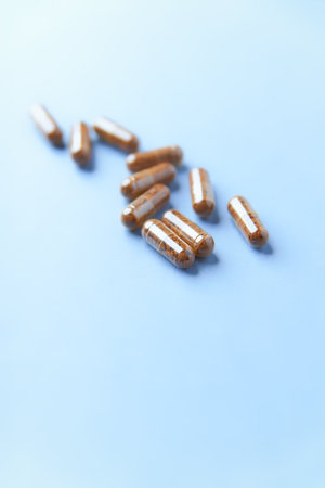 Capsules of pills on a blue background with copy space.の写真素材