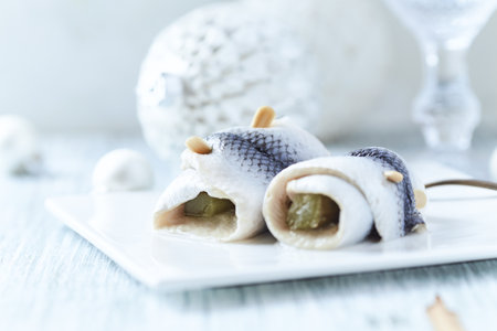 Salted herring fillets on a white plate, selective focus