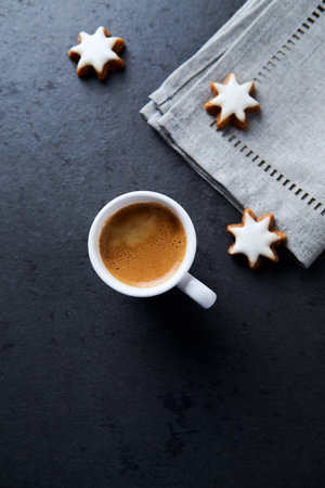 Cup of coffee with cookies on black stone background. Top viewの写真素材