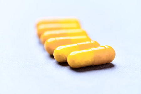 Yellow pills on a white background. Focus on foreground, soft bokeh.の写真素材