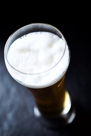 Glass of beer on a dark background. Shallow doof.の写真素材