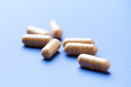 Heap of pills on blue background. Focus on foreground, soft bokeh.