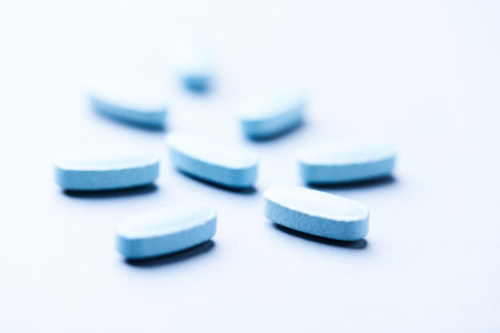 Blue pills on white background. Focus on foreground, soft bokeh.の写真素材