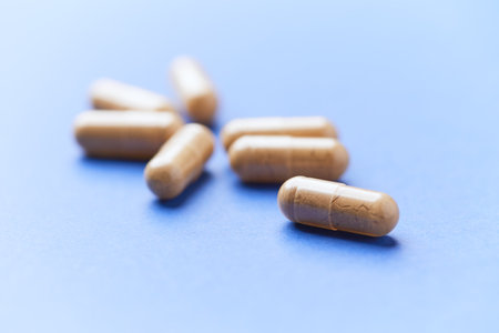 Capsules of pills on a blue background. Selective focus.