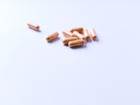 Close up of medical capsules on white background. Selective focus.