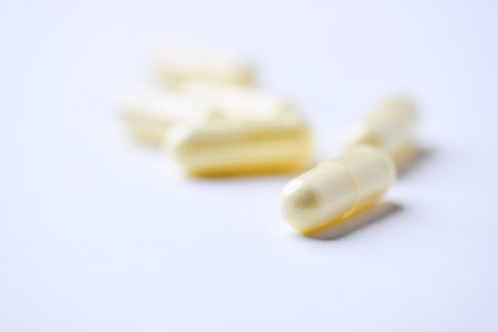 Yellow pills on white background. Focus on foreground, soft bokeh.の写真素材