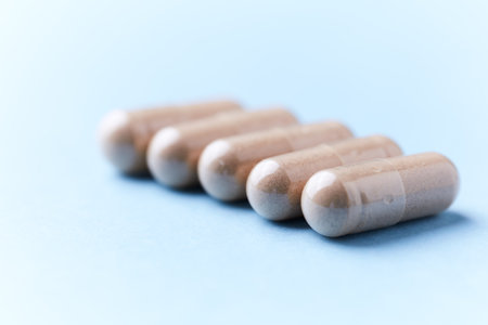 Pills on a blue background. Focus on foreground, soft bokeh.の写真素材