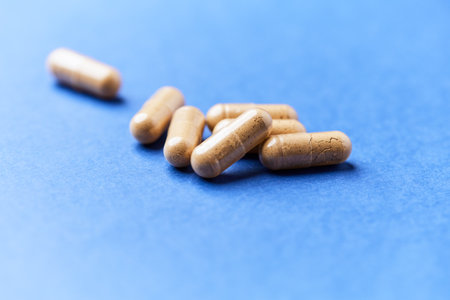 Pills on a blue background. Focus on foreground, shallow DOF.
