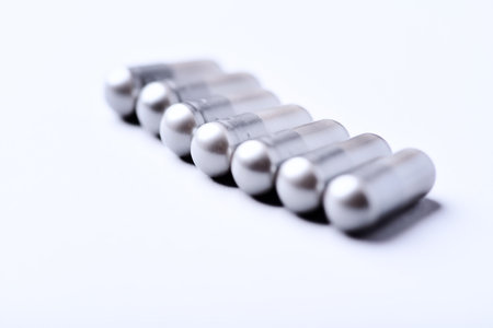 Close-up of silver pills on white background. Focus on foreground.
