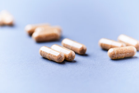 Pills on blue background. Focus on foreground, shallow DOF.