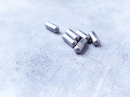 Metal pills on gray background. Focus on foreground, shallow DOF.の写真素材