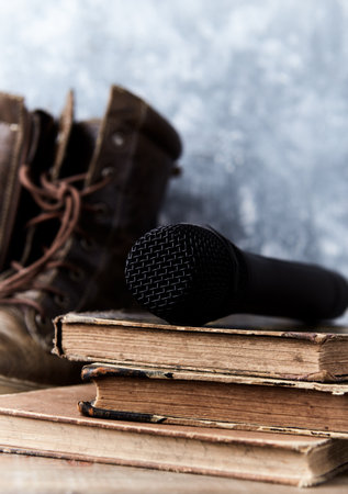 Microphone and old books on a wooden table. Music concept.の写真素材