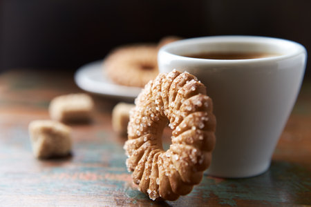 Cup of coffee with cookies on a wooden table, selective focus