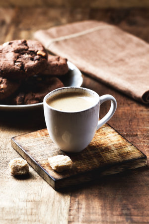 Cup of coffee and chocolate cookies on wooden background, selective focusの写真素材