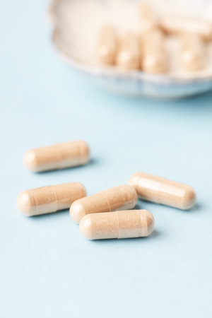Pills on a blue background. Focus on foreground, soft bokeh.の写真素材