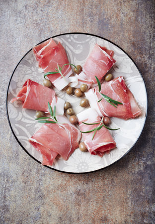 Italian prosciutto crudo or jamon with olives and rosemaryの写真素材
