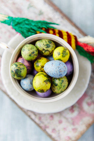 Colorful easter eggs in a bowl and on a wooden background