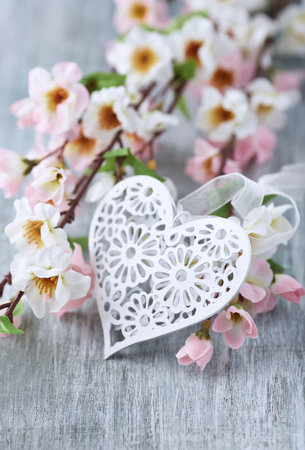 Beautiful spring flowers and heart on wooden background