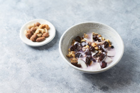 Healthy breakfast bowl with granola, yogurt and nuts on concrete background.の写真素材