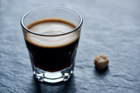 Coffee espresso in a glass on a dark stone background.