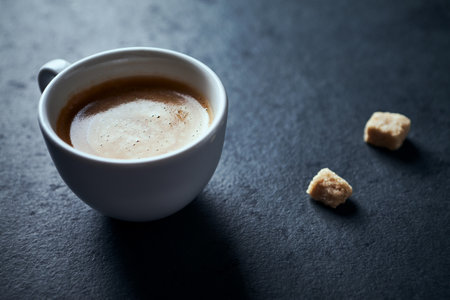 Coffee cup with sugar cubes on black background, top viewの写真素材