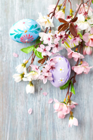 Easter eggs and spring blossom on wooden background, selective focusの写真素材