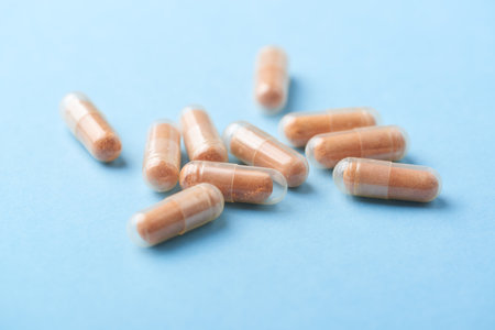 Capsule pills on blue background. Close up of medical capsules.の写真素材