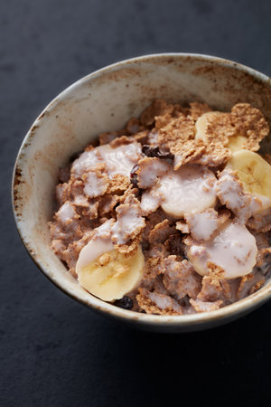 Muesli with banana and nuts in a bowl, selective focus