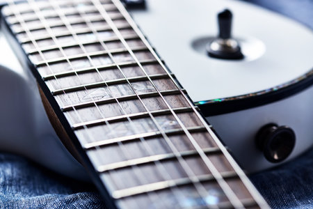 Closeup of electric guitar on blue jeans background, selective focus.の写真素材