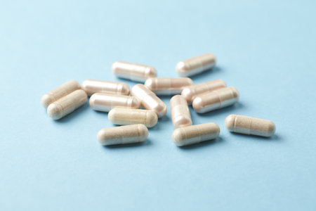 Close up of a pile of pills on blue background with copy spaceの写真素材
