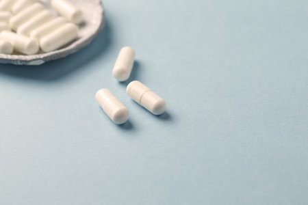 white pills on a blue background with copy space. Focus on foreground