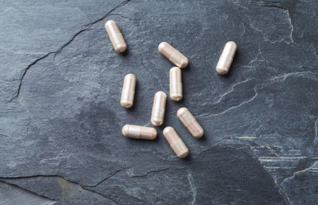 Herbal medicine capsules on black stone background. Top view with copy spaceの写真素材