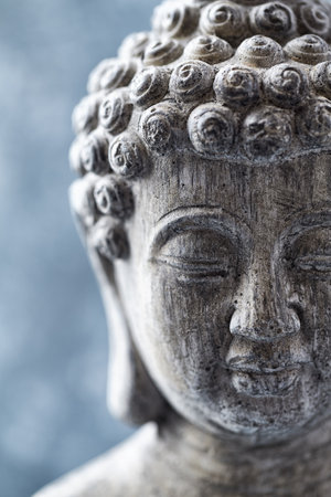 Buddha statue on blue background, closeup of photo.の写真素材