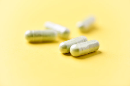 Pills on yellow background. Focus on foreground, soft bokeh.