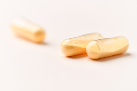 Close up of two yellow pills on white background. Focus on foreground.の写真素材