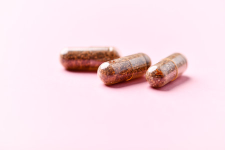 Pills in copper on a pink background. Selective focus.