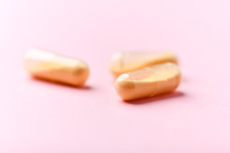 Capsules of omega 3 fish oil on a pink background.の写真素材