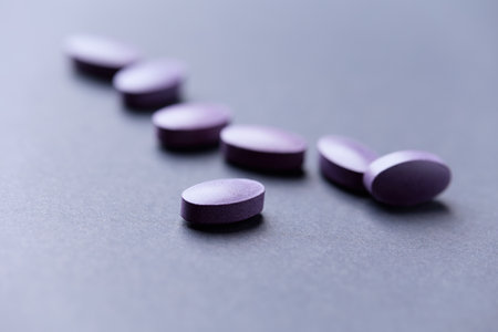 Purple pills on gray background. Focus on foreground, soft bokeh.の写真素材