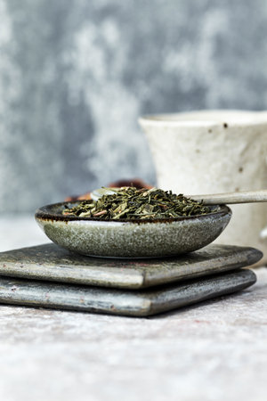 Herbal tea in a bowl on a gray background. Selective focus.