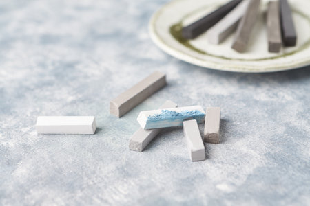 Pieces of chalk on a plate, close-up, selective focus.の写真素材