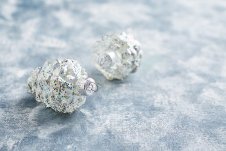 Silver Christmas tree toys on a light background. New Year and Christmas concept.の写真素材