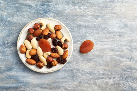 Healthy mix of nuts, raisins and dates on rustic wooden background. Top view, copy spaceの写真素材