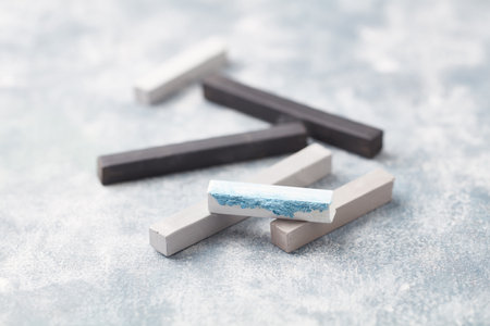 Pieces of chalk in a row on a light blue background.の写真素材