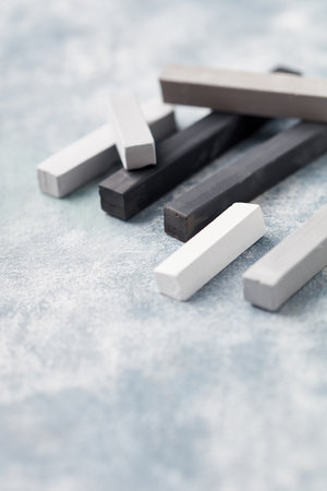Black and white chalk on a light blue stone background. Selective focus.の写真素材
