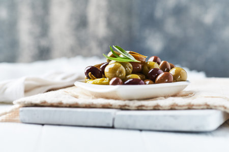 Olives with olive oil in a bowl on a wooden background.の写真素材