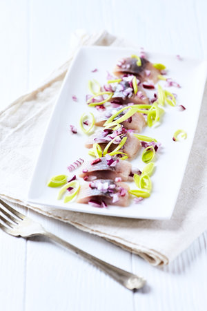 Marinated herring fillet with onion and lemon, selective focusの写真素材